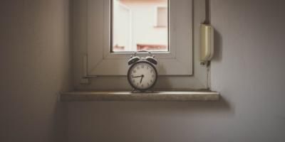 Reloj despertador sobre el alfeizar de una ventana. Photo by David von Diemar on Unsplash